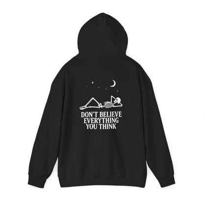Minimalist skeleton silhouette hoodie with gothic quote “Don’t believe everything you think” under crescent moon and stars – SkeletonWear Apparel