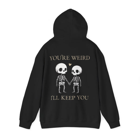 Two skeletons holding hands with a red heart, quirky “You’re Weird I’ll Keep You” text, gothic skeleton couple hoodie by SkeletonWear Apparel