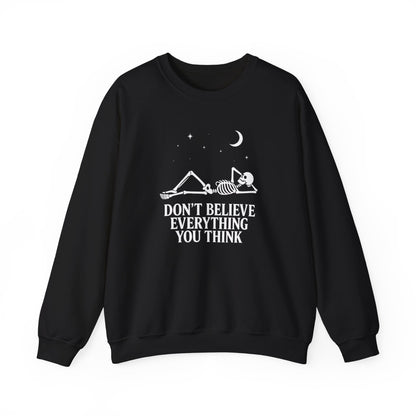 Minimalist skeleton silhouette sweatshirt with gothic quote “Don’t believe everything you think” under crescent moon and stars – SkeletonWear Apparel