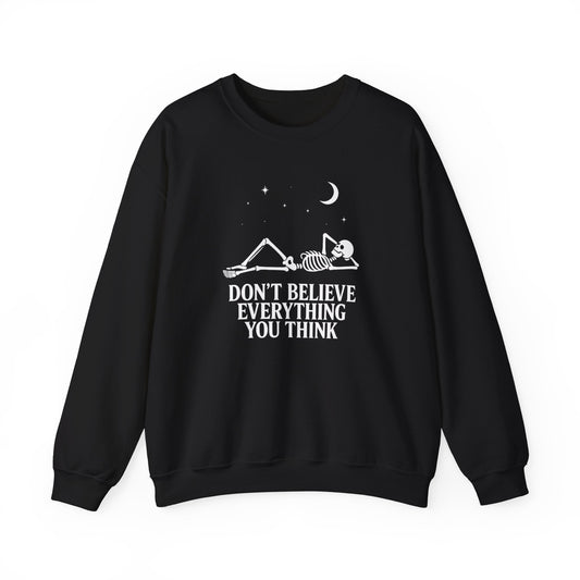 Minimalist skeleton silhouette sweatshirt with gothic quote “Don’t believe everything you think” under crescent moon and stars – SkeletonWear Apparel