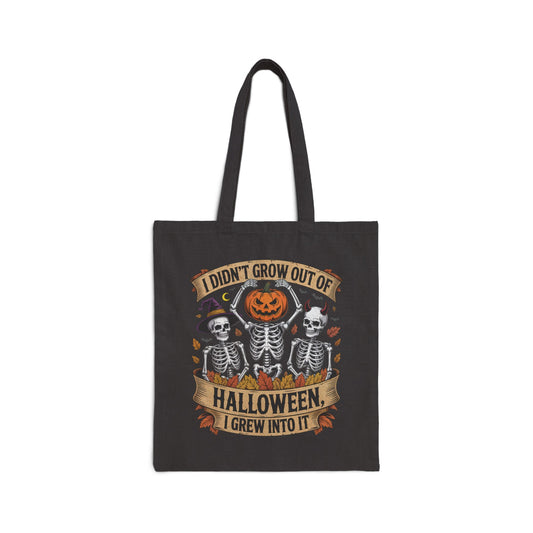 Skeletons with pumpkin, witch hat, and devil horns under banner ‘I Didn’t Grow Out of Halloween, I Grew Into It’ – SkeletonWear Apparel Halloween tote bag design