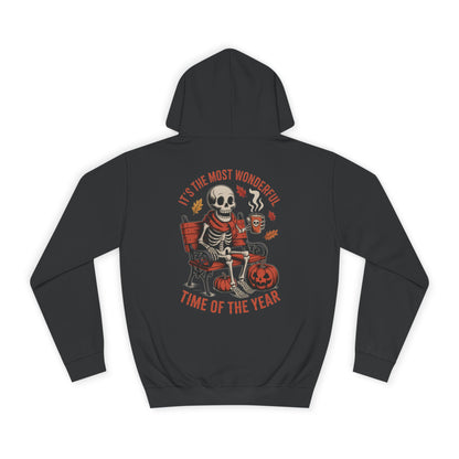Skeleton wearing scarf drinking pumpkin spice latte on gothic bench with pumpkins and autumn leaves – cozy Halloween hoodie design by SkeletonWear Apparel